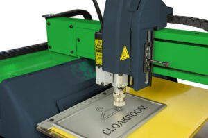 Equipo M40 grabando una placa metálica con logotipo en taller colombiano, demostrando precisión y facilidad de uso.