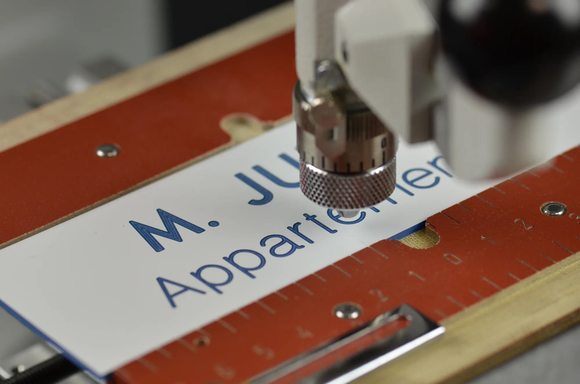 Máquina de grabado manual IM3 de Gravotech grabando una placa metálica